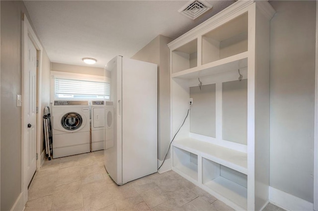 clothes washing area with visible vents and washer and clothes dryer
