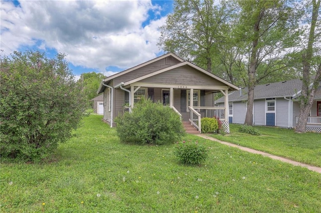 bungalow-style home featuring covered porch and a front yard
