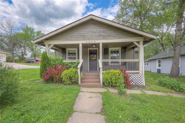 bungalow-style home featuring covered porch and a front yard