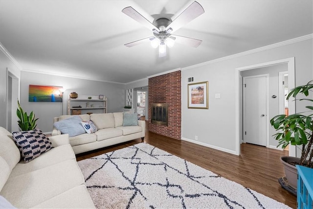 living area with baseboards, ornamental molding, a brick fireplace, and wood finished floors