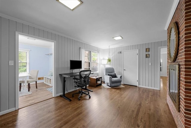 office area with crown molding, plenty of natural light, and wood finished floors