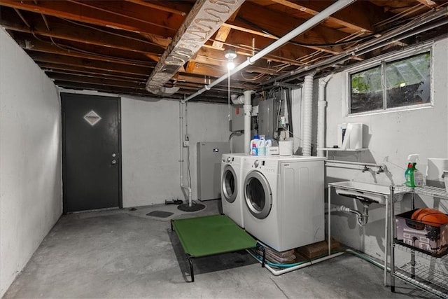 laundry area with electric panel, laundry area, a sink, and washer and dryer