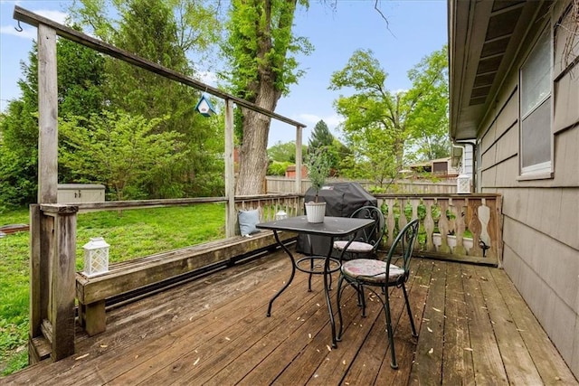 wooden terrace with a lawn and fence