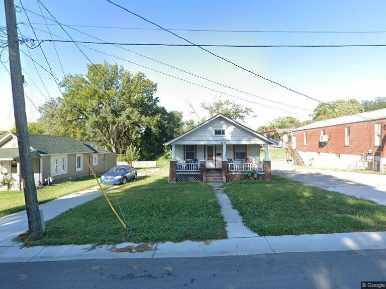 bungalow-style home with covered porch and a front yard