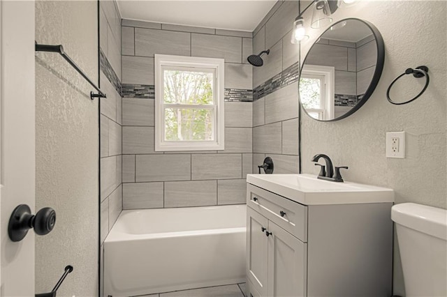 bathroom featuring  shower combination, toilet, a textured wall, and vanity
