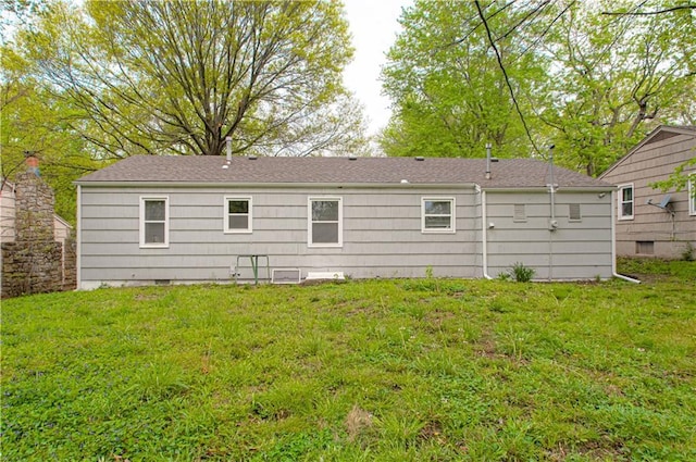 rear view of property featuring a yard