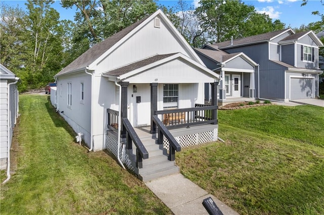 69 N Valley St, Kansas City, KS 66102 - view of front facade featuring covered porch, roof with shingles, a front lawn, and driveway