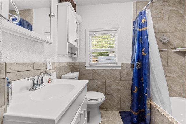 69 N Valley St, Kansas City, KS 66102 - full bathroom featuring tile walls, toilet, tile patterned floors, vanity, and tiled shower / bath