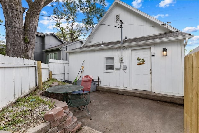 69 N Valley St, Kansas City, KS 66102 - rear view of house with a patio, fence, and roof with shingles