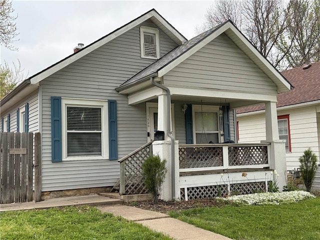 1450 Central St, Leavenworth, KS 66048 - bungalow-style house with roof with shingles, fence, a front lawn, a porch, and a chimney