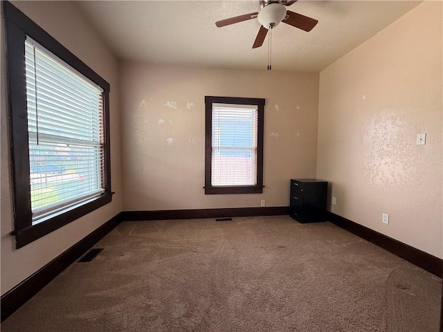 1450 Central St, Leavenworth, KS 66048 - carpeted empty room featuring baseboards, ceiling fan, visible vents, and a wealth of natural light