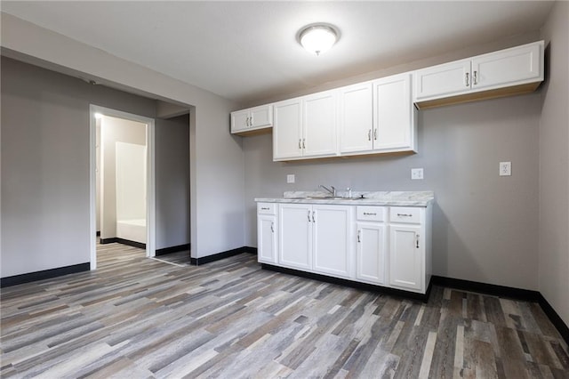 707 S Market St, Holden, MO 64040 - kitchen featuring baseboards, white cabinetry, and light wood-style floors