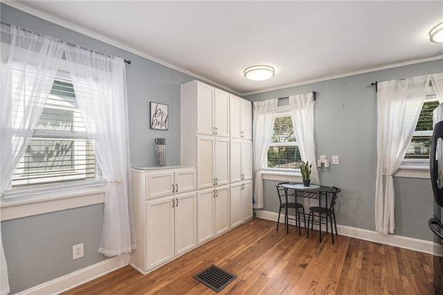 interior space with wood finished floors, visible vents, and baseboards
