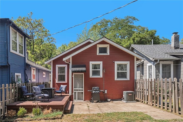 rear view of property featuring a deck, a chimney, fence private yard, a patio area, and cooling unit
