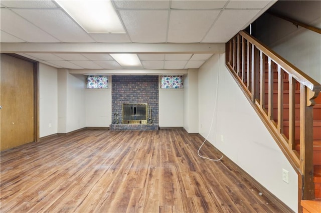 3311 S Crane St, Independence, MO 64055 - finished below grade area with wood finished floors, a fireplace, a drop ceiling, stairs, and baseboards