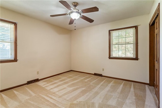 3311 S Crane St, Independence, MO 64055 - unfurnished bedroom with multiple windows, light carpet, baseboards, and ceiling fan