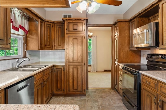 3311 S Crane St, Independence, MO 64055 - kitchen with appliances with stainless steel finishes, brown cabinets, light countertops, a sink, and ceiling fan