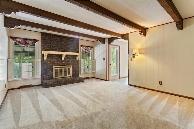 3311 S Crane St, Independence, MO 64055 - unfurnished living room with beamed ceiling, carpet floors, a brick fireplace, baseboards, and wood walls