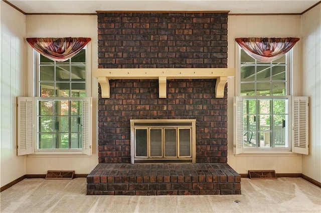 3311 S Crane St, Independence, MO 64055 - detailed view of baseboards, a brick fireplace, ornamental molding, and carpet floors