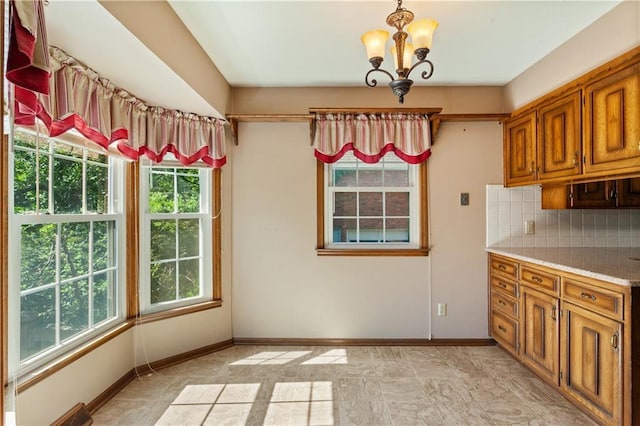 3311 S Crane St, Independence, MO 64055 - unfurnished dining area with plenty of natural light, a chandelier, and baseboards