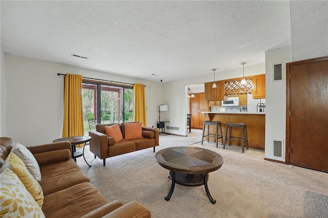 living room featuring light colored carpet, a textured ceiling, and baseboards