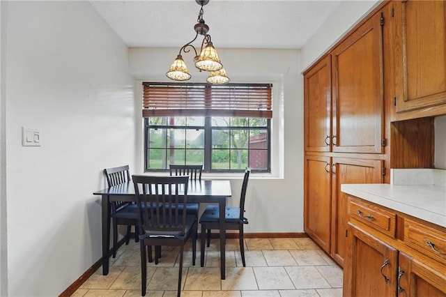 dining area featuring a chandelier, baseboards, and light tile patterned flooring