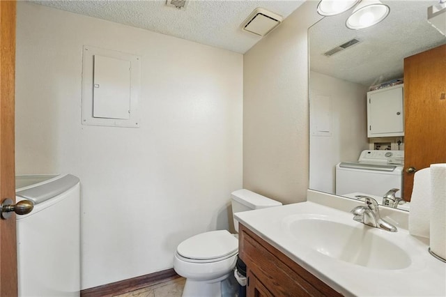 half bathroom featuring washer / clothes dryer, electric panel, toilet, a textured ceiling, and vanity