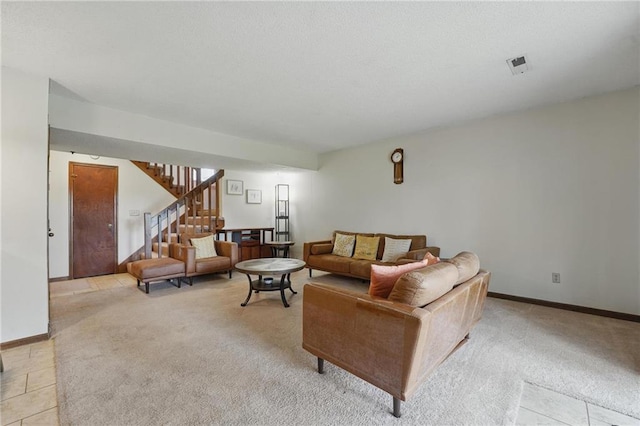 living area featuring stairway, light carpet, baseboards, and light tile patterned floors