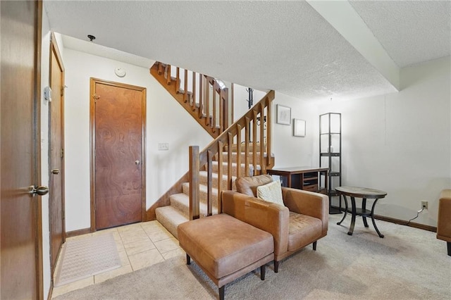 entrance foyer with a textured ceiling, stairway, light carpet, and baseboards