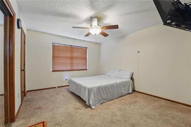 bedroom with carpet floors, baseboards, ceiling fan, and a textured ceiling