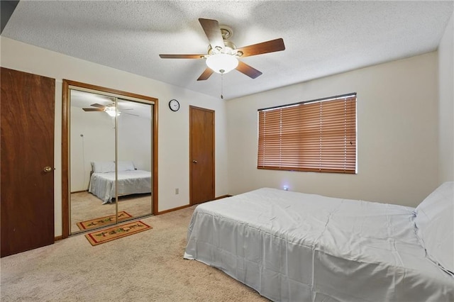 carpeted bedroom featuring two closets, a ceiling fan, and a textured ceiling