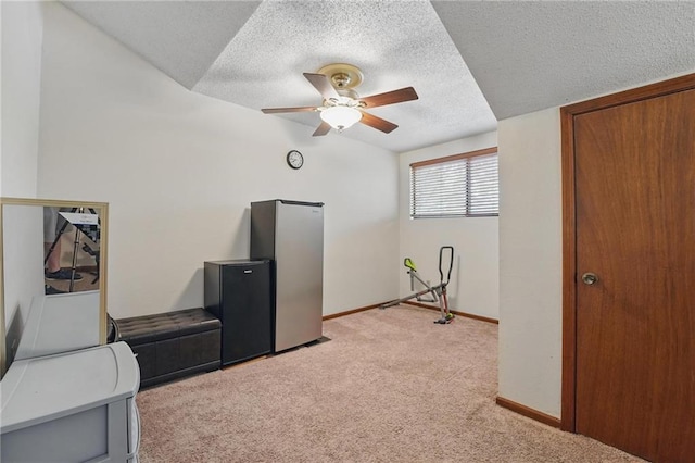 unfurnished room featuring light colored carpet, a textured ceiling, ceiling fan, and baseboards