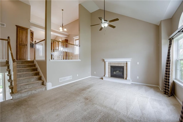 unfurnished living room featuring high vaulted ceiling, visible vents, carpet, and ceiling fan with notable chandelier