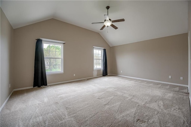 carpeted empty room with plenty of natural light, baseboards, ceiling fan, and lofted ceiling