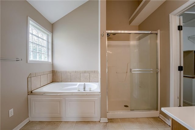 bathroom featuring a garden tub, tile patterned flooring, a stall shower, baseboards, and lofted ceiling