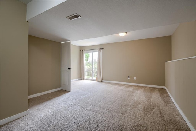unfurnished room featuring visible vents, baseboards, and light carpet