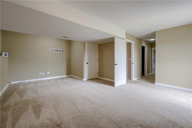 below grade area with visible vents, baseboards, and light carpet