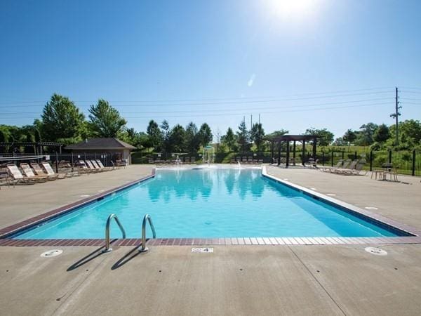 pool featuring fence and a patio