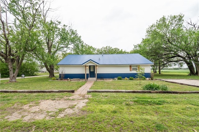 ranch-style home featuring a front yard and metal roof
