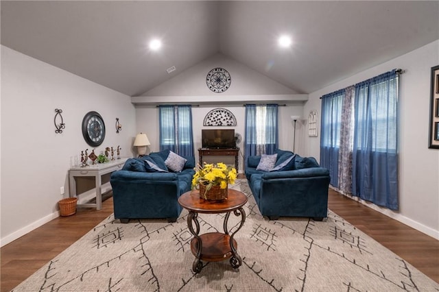 living room featuring baseboards, wood finished floors, and vaulted ceiling