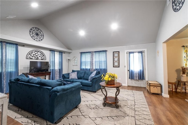 living area featuring wood finished floors, recessed lighting, high vaulted ceiling, and baseboards