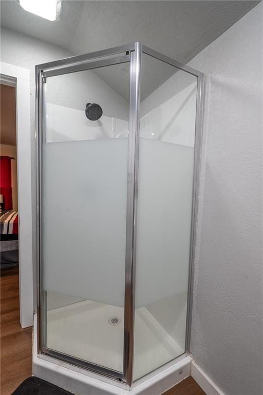 full bath featuring a shower stall and wood finished floors