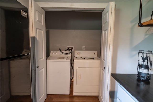 clothes washing area with washing machine and clothes dryer, laundry area, and dark wood finished floors