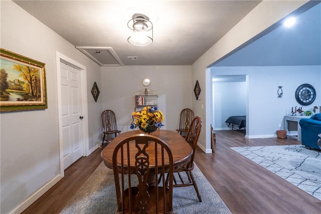 dining room featuring dark wood finished floors, visible vents, and baseboards