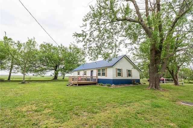 back of house with a wooden deck and a lawn
