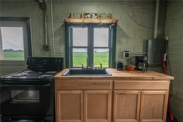 kitchen featuring black electric range oven, a sink, butcher block counters, and plenty of natural light