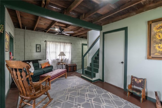 living area with beamed ceiling, stairs, wooden ceiling, and ceiling fan