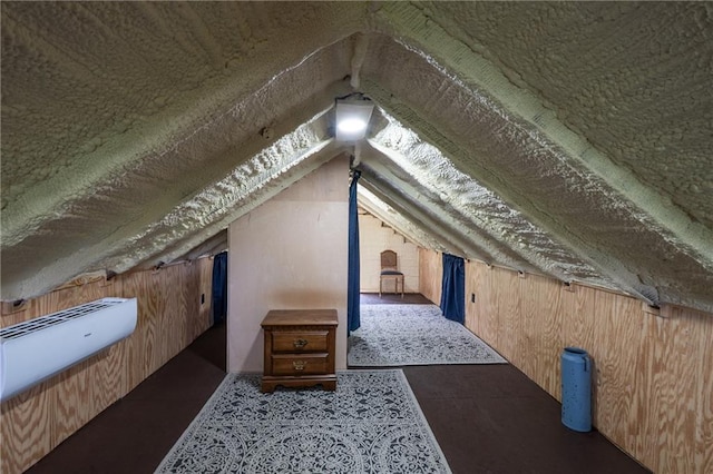 bonus room featuring vaulted ceiling and wood walls
