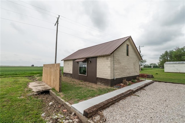 view of side of property featuring a yard and metal roof