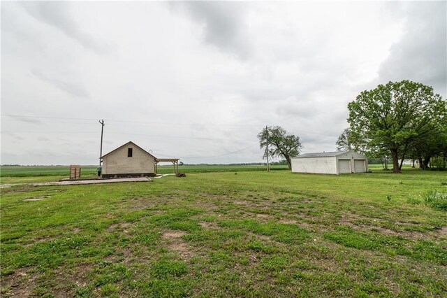 view of yard with a detached garage and an outdoor structure